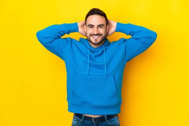 Sarı arka planda izole edilmiş genç beyaz yakışıklı adam gülüyor.