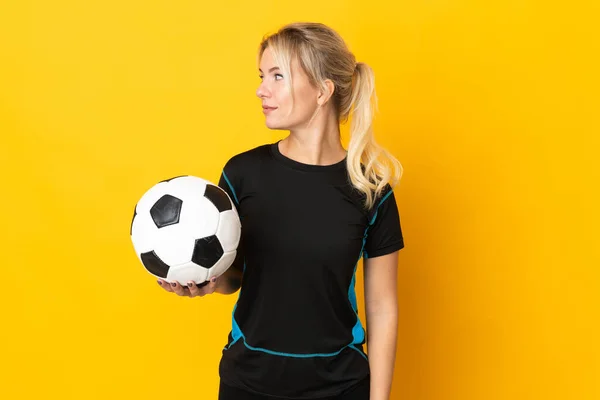 若いですロシアのサッカー選手の女性は黄色の背景に孤立しました側面を見ます — ストック写真