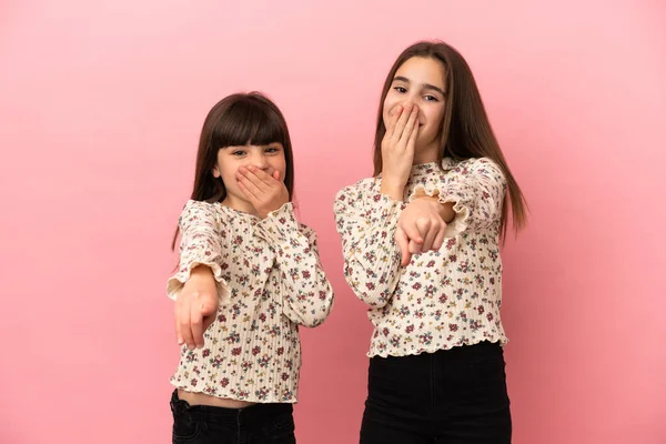 Kleine Zusjes Meisjes Geïsoleerd Roze Achtergrond Wijzend Met Vinger Naar — Stockfoto