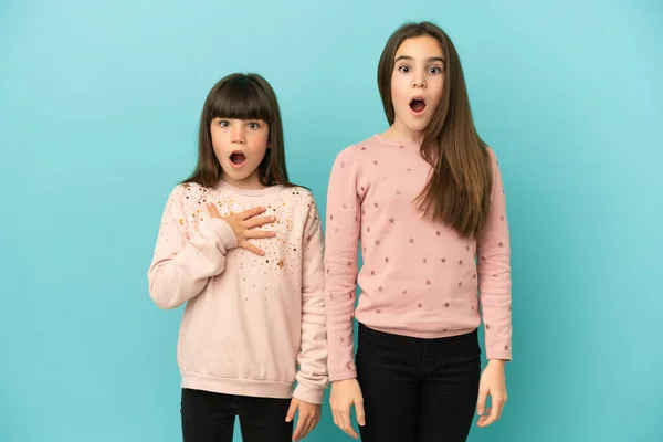 Små Systrar Flickor Isolerade Blå Bakgrund Med Överraskning Och Chockad — Stockfoto