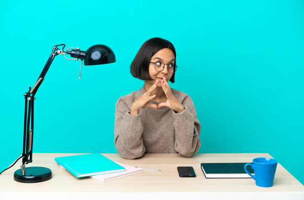 Young student mixed race woman studying on a table scheming something