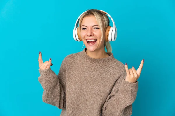 Νεαρή Ρωσίδα Απομονωμένη Μπλε Φόντο Ακούγοντας Μουσική Κάνοντας Ροκ Χειρονομία — Φωτογραφία Αρχείου