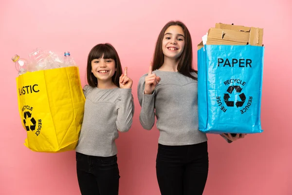 Küçük Kız Kardeşler Geri Dönüşüm Kağıdını Plastiği Pembe Arka Planda — Stok fotoğraf