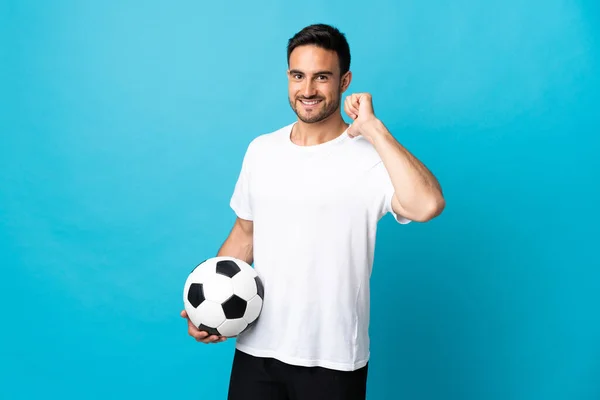 Genç Yakışıklı Adam Mavi Arka Planda Izole Edilmiş Futbol Topuyla — Stok fotoğraf