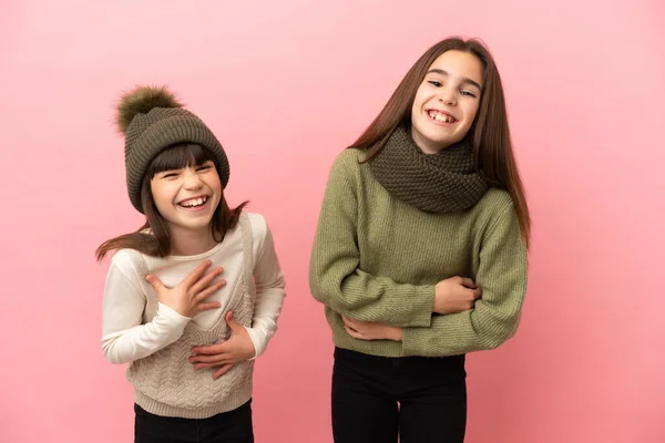 Hermanitas Vistiendo Una Ropa Invierno Aisladas Sobre Fondo Rosa Sonriendo —  Fotos de Stock