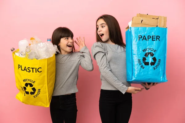 Küçük Kız Kardeşler Geri Dönüşüm Kağıtlarını Plastikleri Pembe Arka Planda — Stok fotoğraf