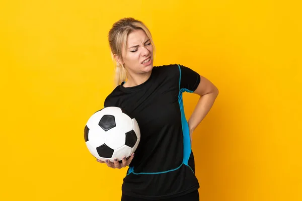 若いロシアのサッカー選手の女性は努力をしたことのために腰痛に苦しんで黄色の背景に隔離されました — ストック写真
