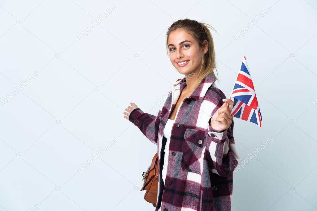 Young woman holding an UK flag isolated on white background extending hands to the side for inviting to come