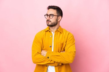 Pembe arka planda izole edilmiş beyaz, yakışıklı genç bir adam.