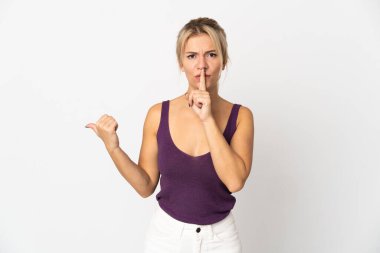 Beyaz arka planda izole edilmiş genç bir Rus kadın, kenarı işaret ediyor ve sessiz hareketler yapıyor.