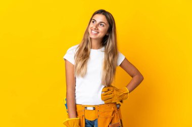 Genç İspanyol elektrikçi kadın, izole edilmiş sarı duvardan yukarı bakarken bir fikir düşünüyor.