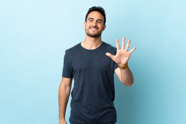 Tecrit edilmiş genç yakışıklı adam parmaklarıyla beşi sayıyor.