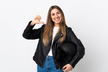 İzole edilmiş beyaz arka planda motosiklet kaskı tutan genç bir kadın gururlu ve kendini beğenmiş.