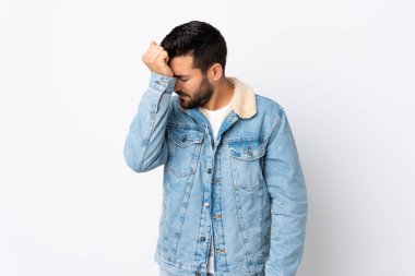 Beyaz arka planda sakallı, yakışıklı ve baş ağrısı olan genç bir adam.