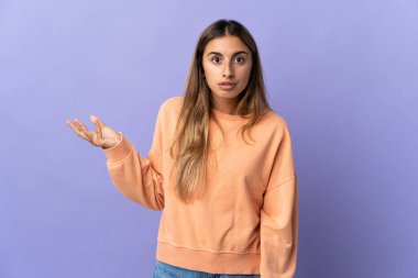 Soyutlanmış mor arka planda genç İspanyol kadın şüpheli hareketler yapıyor.