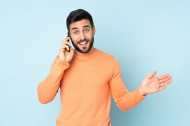 Kafkasyalı yakışıklı bir adam cep telefonuyla sohbet ediyor.