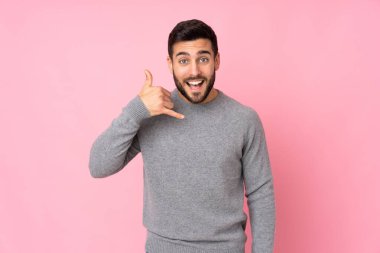 Kafkasyalı yakışıklı bir adam izole edilmiş bir şekilde telefon jesti yapıyor. Bana geri dönüş işareti ver.