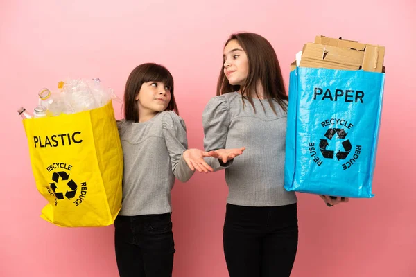 Küçük Kız Kardeşler Pembe Arka Planda Izole Edilmiş Kağıt Plastikleri — Stok fotoğraf
