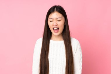 Asyalı genç bir kadın izole edilmiş arka planda, ağzı açık bağırıyor.