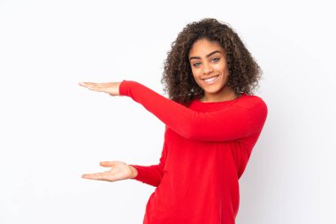 Genç Afrikalı Amerikalı bir kadın, arka planda izole edilmiş bir ilan vermek için kopyalama alanı tutuyor.