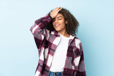 Mavi arka planda izole edilmiş genç Afrikalı Amerikalı kadın bir şey fark etti ve çözüme niyetlendi.