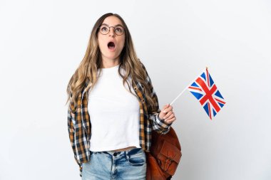 Beyaz zemin üzerinde izole edilmiş bir Birleşik Krallık bayrağı taşıyan genç Romen kadın yukarı bakıyor ve şaşırmış bir ifadeyle