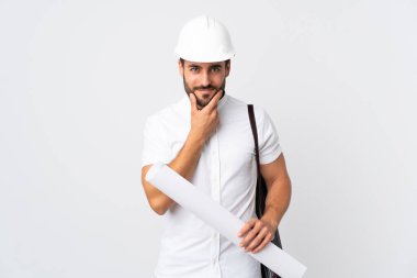 Miğferli ve elinde beyaz arka planda izole planlar tutan genç bir mimar.