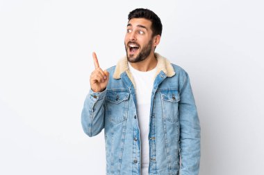 Beyaz arka planda sakallı yakışıklı genç adam çözümü bulmak için parmağını kaldırıyor.