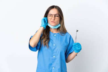 Romen kadın diş hekimi pembe arka planda izole edilmiş araçlar taşıyor