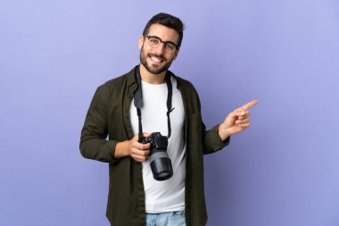 İzole edilmiş mor arkaplan üzerinde fotoğrafçı parmak kenarı gösteriyor.