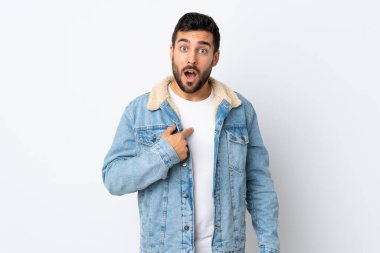 Beyaz arka planda sakallı yakışıklı genç adam kendini işaret ediyor.
