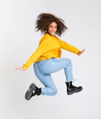 Genç Afrikalı Amerikalı kadın izole beyaz arka planda dans ediyor.