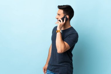 Tecrit edilmiş genç ve yakışıklı bir adam cep telefonuyla sohbet ediyor.