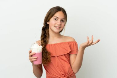 Beyaz arka planda izole edilmiş çilekli milkshake 'li küçük beyaz kız davet etmek için ellerini yana uzatıyor.