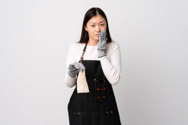 Çinli balıkçı önlük takıyor ve soyutlanmış beyaz arka planda çiğ balık tutuyor mutlu ve elleri ağızda gülümsüyor.