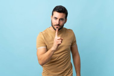 Sakallı, sakallı, soyutlanmış, hayal kırıklığına uğramış ve ön tarafı işaret eden genç bir adam.