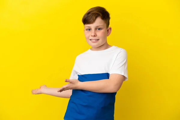 Pequeño Pelirrojo Aislado Sobre Fondo Amarillo Extendiendo Las Manos Lado —  Fotos de Stock