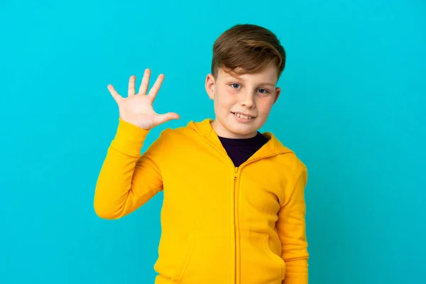 Liten Rödhårig Pojke Isolerad Blå Bakgrund Hälsning Med Handen Med — Stockfoto