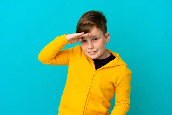 Pequeño Pelirrojo Aislado Sobre Fondo Azul Mirando Lejos Con Mano — Foto de Stock