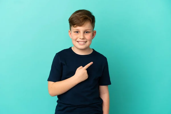 Pequeño Pelirrojo Aislado Sobre Fondo Azul Apuntando Hacia Lado Para — Foto de Stock