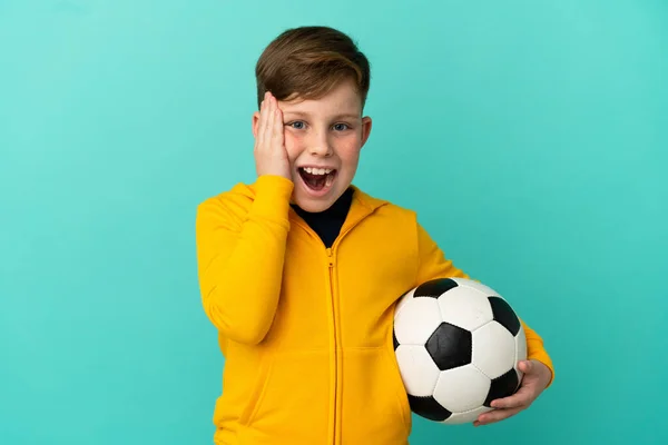 Roodharige Kind Spelen Voetbal Geïsoleerd Blauwe Achtergrond Met Verrassing Geschokt — Stockfoto
