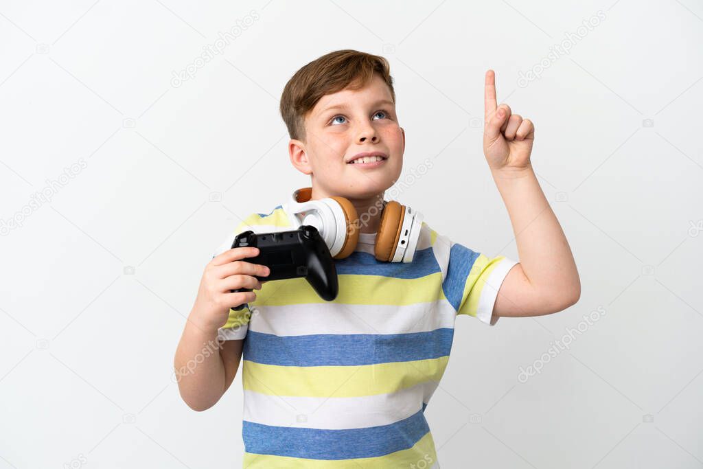 Little redhead boy holding a game pad isolated on white background pointing up a great idea