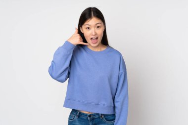 Arka planda izole edilmiş genç Asyalı bir kadın telefon jesti yapıyor. Bana geri dönüş işareti ver.