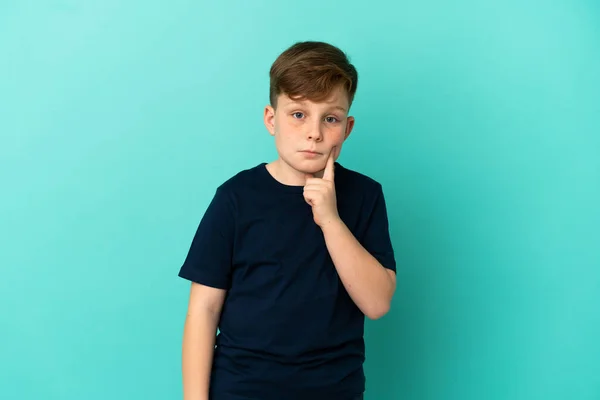 Pequeño Pelirrojo Aislado Sobre Fondo Azul Pensando —  Fotos de Stock