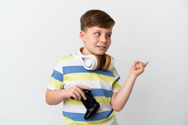 Küçük kızıl saçlı çocuk beyaz arka planda izole edilmiş bir oyun tahtası tutuyor. Çözümü bulmak için parmağını kaldırıyor.