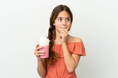 Beyaz arka planda izole edilmiş çilekli milkshake 'li beyaz bir kız şüpheleri ve düşünceleri var.