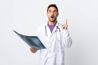 Beyaz arka planda izole edilmiş bir radyografi tutan genç doktor işaret parmağıyla işaret etmek harika bir fikir.