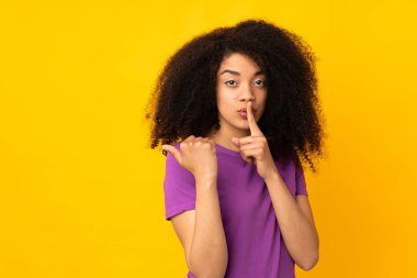 Tecrit edilmiş bir geçmişi olan genç Afro-Amerikalı bir kadın tarafından işaret ediliyor ve sessizlik hareketi yapıyor.