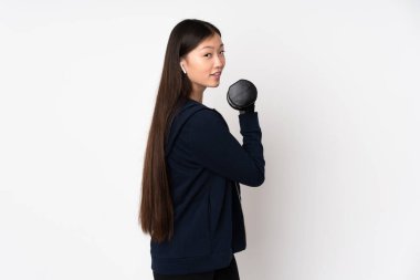 Beyaz arka planda izole edilmiş genç Asyalı kadın halter yapıyor.