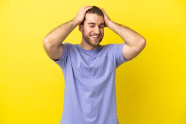 Sarışın yakışıklı adam izole edilmiş sarı arka planda gülüyor.